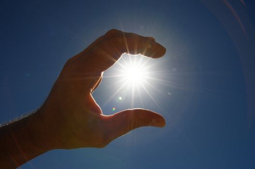 One Hand Catching the Sun Stars on a Blue Background