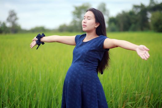 Pregnant woman on green meadow.