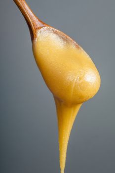 Honey dripping from a wooden honey dipper