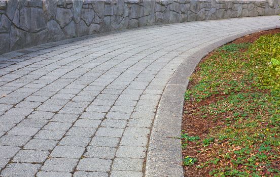 Curved stone path with stone wall