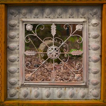 Fancy woos framed home yard fence with soft background rock and plants