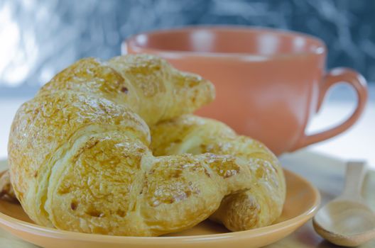 close up  croissants on  brown dish  and a cup of coffee