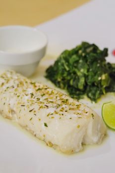 close up grilled fish with vegetable on white dish