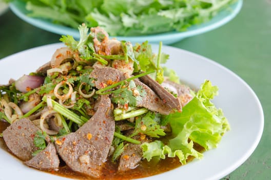 close up spicy sliced liver salad with fresh vegetable on dish , asian spicy food