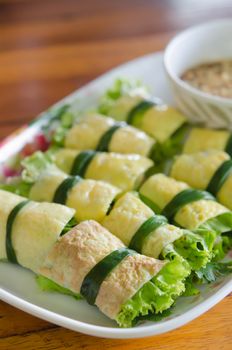 close up fried egg rolled with fresh vegetable , ( cuon hanh )