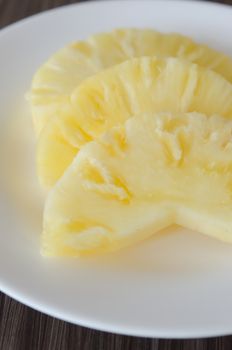 slices of  fresh pineapple  on white dish