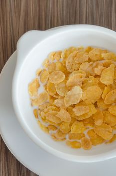 top view corn flake cereal with fresh  milk in white bowl