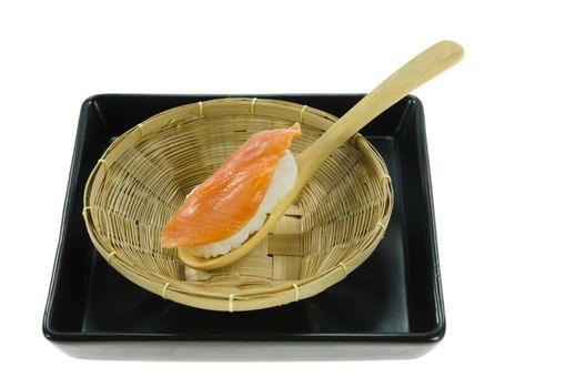 close up salmon sushi with wooden spoon and basket , dish over white