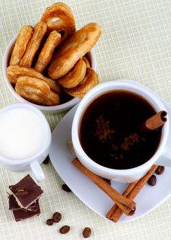 Arrangement of Coffee Cup, Milk and Puff Pastry with Chocolate, Sugar and Cinnamon Sticks. Top View