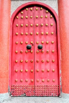 Chinese red door in temple with a lion/dragon handles