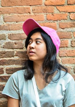 Asian girl wear hat over brick wall