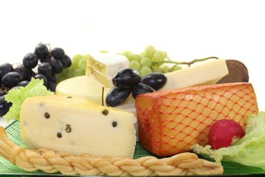 different types of cheese on a green glass plate