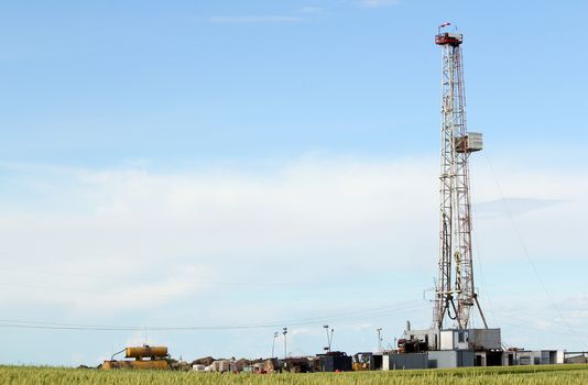 land oil drilling rig in green wheat field