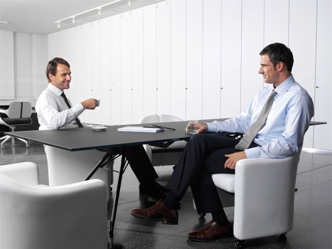 businesspeople having a business meeting at coffee table in office lobby