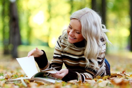 woman read the book in autumn park