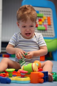 A baby boy crying in children's room