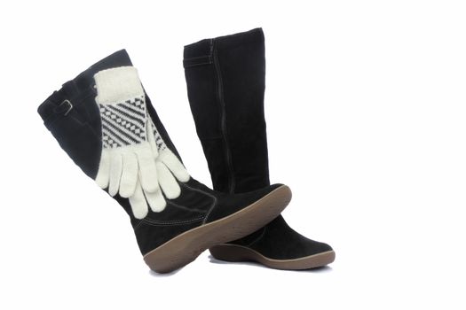 
Winter suede black boots and white with black ornament gloves. Presented on a white background.