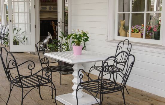 Black iron chairs on the front porch.