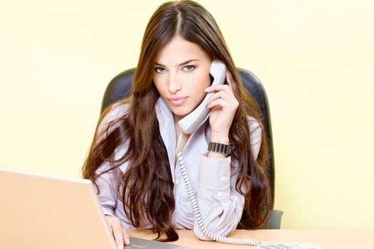 Pretty business woman in office having a telephone call