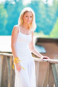 Young slim woman in white at the railing