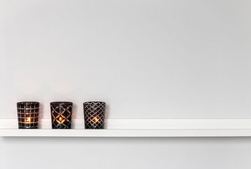 Home decor, candle lights on a white shelf.