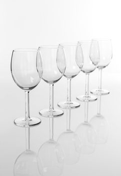 Row of empty wineglasses, with reflection.