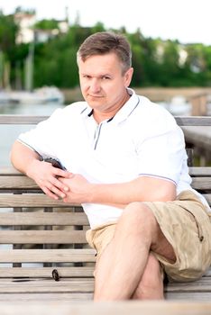Middle aged men sitting on bench with suspicious look