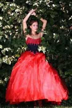 Young woman in a red gothic dress