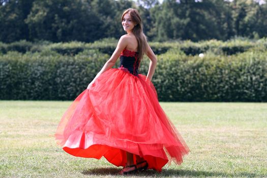 Young woman in a red gothic dress