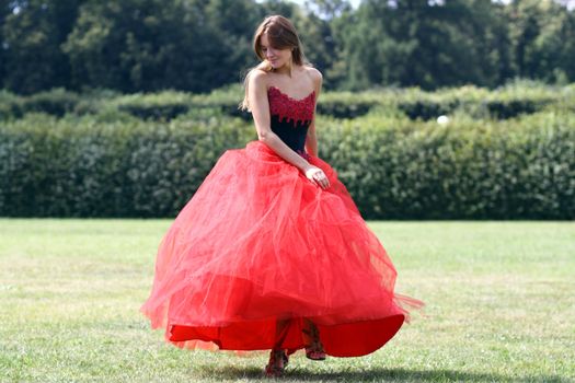Young woman in a red gothic dress