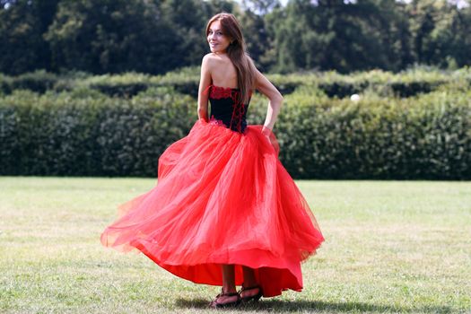 Young woman in a red gothic dress