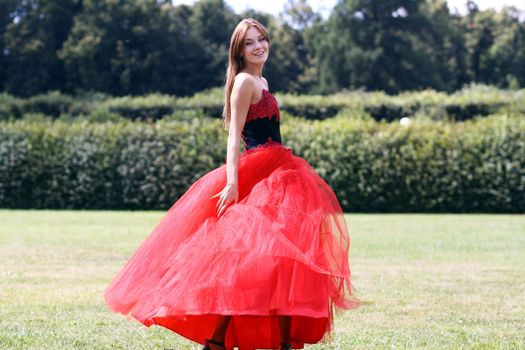 Young woman in a red gothic dress