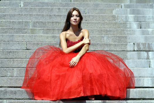 Young woman in a red gothic dress