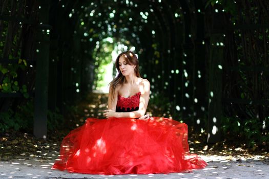 Young woman in a red gothic dress
