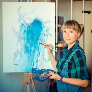 beautiful blonde woman painter in her studio