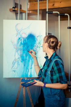 beautiful blonde woman painter in her studio