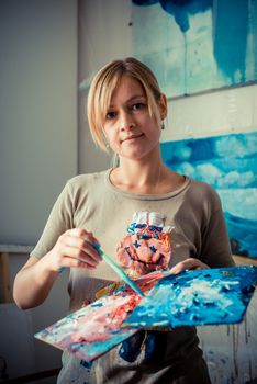 beautiful blonde woman painter in her studio