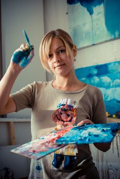 beautiful blonde woman painter in her studio