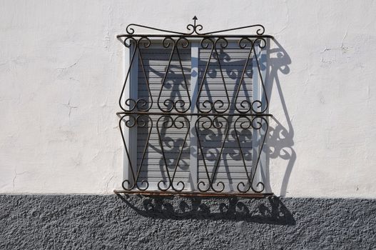 window with metal grate on a colored wall