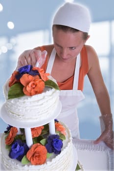 Woman with white bandanna giving to a wedding cake latest small retouches