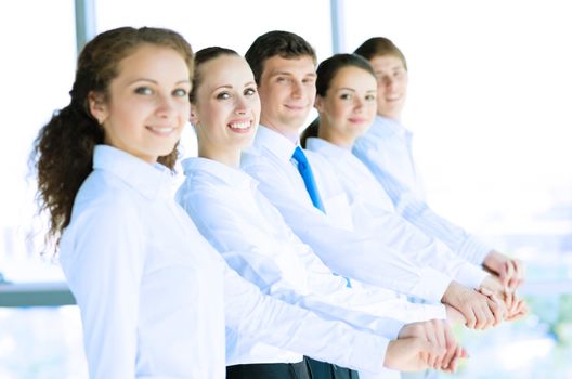 young business people holding hands, standing in a row, the concept of teamwork