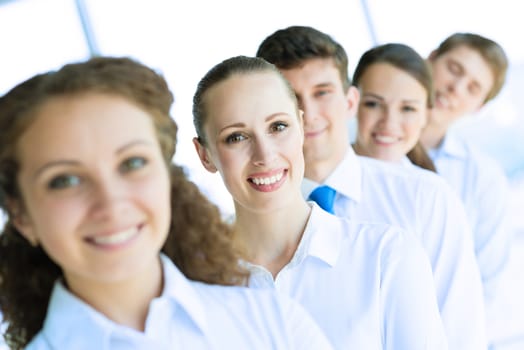 portrait of a young business woman standing in line with colleagues, concept of teamwork