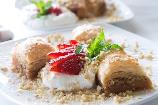 Baklava Served with Strawberry and full fat cream and garnished with mint leaves