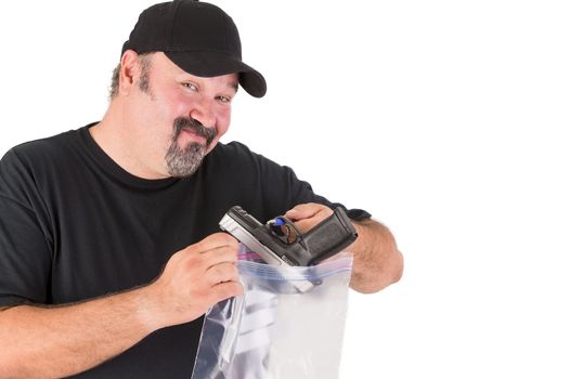 Crime scene investigator founds a gun, he has a sure look on his face while he is placing gun in to a evidence bag