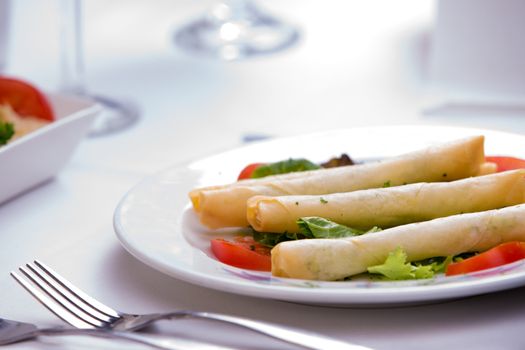 Turkish style cheese stuffed filo dough rolls served along with tomatoes and lettuce