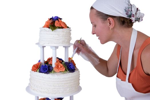 Baker lady giving to a wedding cake latest small retouches, cake has fondant ruffles on the side and decorated with orange and purple gum paste roses
