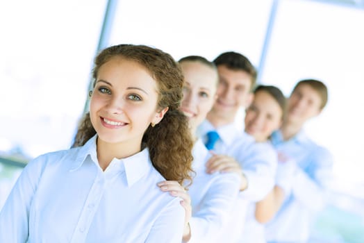 portrait of a young business woman standing in line with colleagues, concept of teamwork