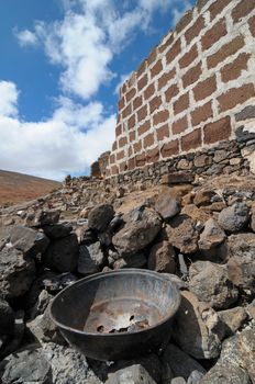 rusty aged metal near a wall on a loudy sky