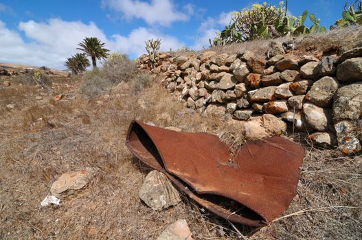 Rusty barrel in the desert on a cloudy sky