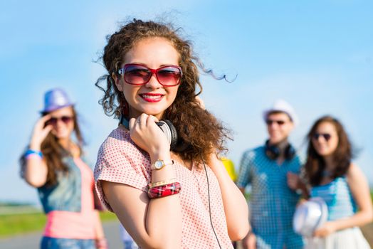 young woman with headphones on a background of blue sky and funny friends